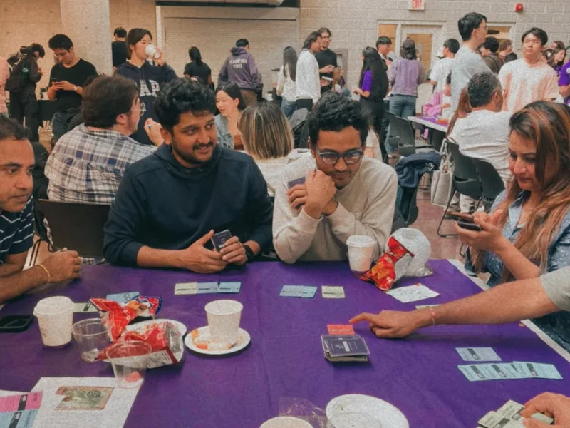 Players leaning into the table with handmade UNICORN cards during a prototype session